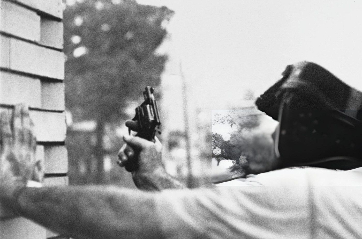 A Newark police officer shelters from a sniper