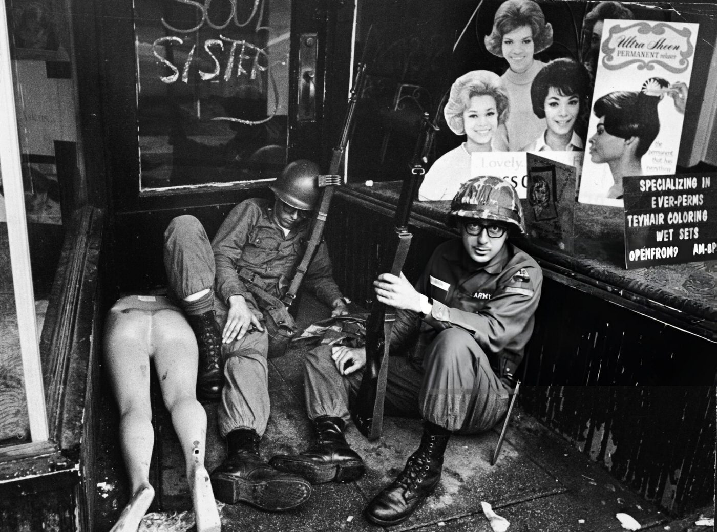 National Guardsmen rest in front of a hairdressers shop