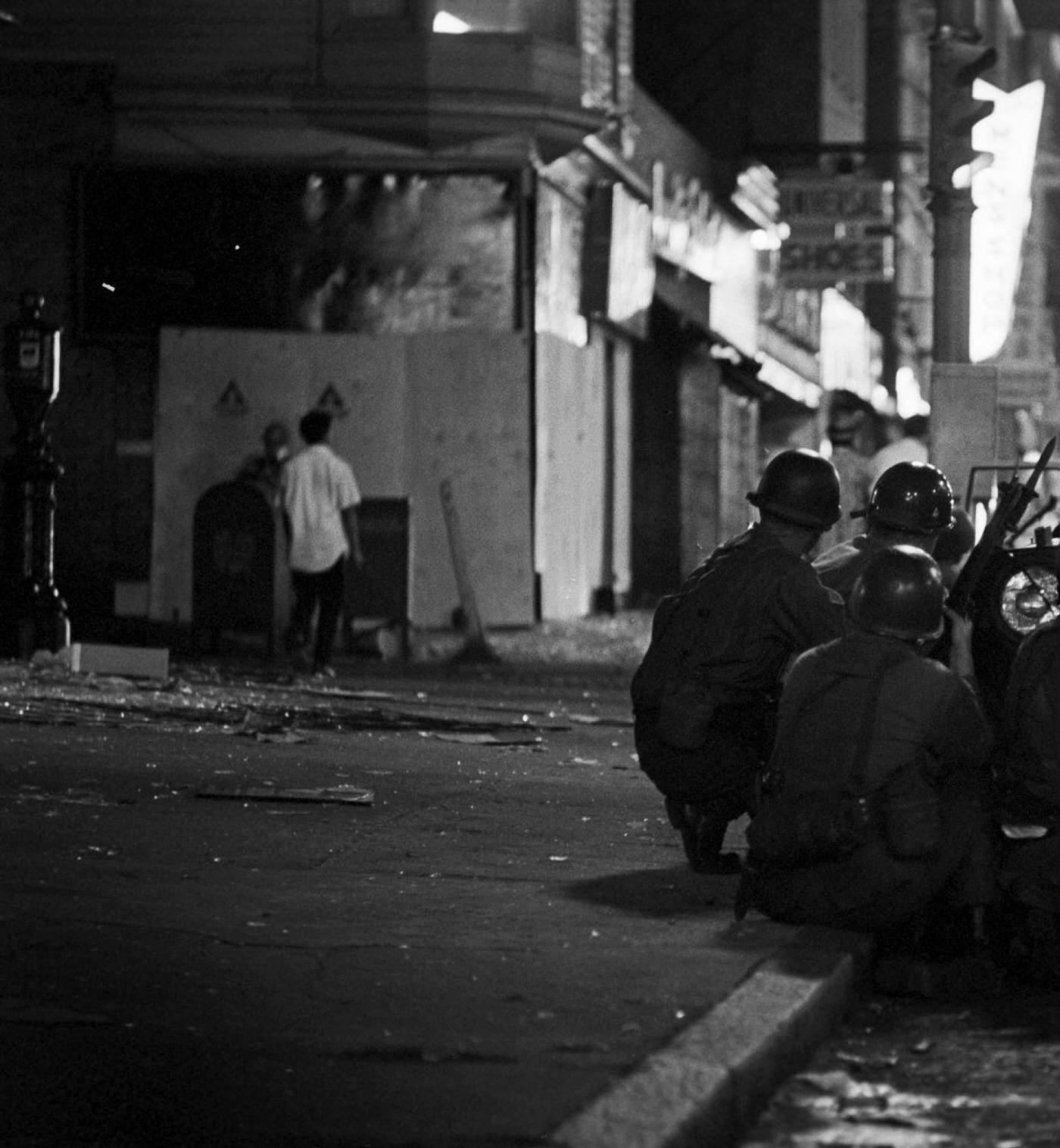 National Guard soldiers take cover behind a jeep armed with a light machine gun