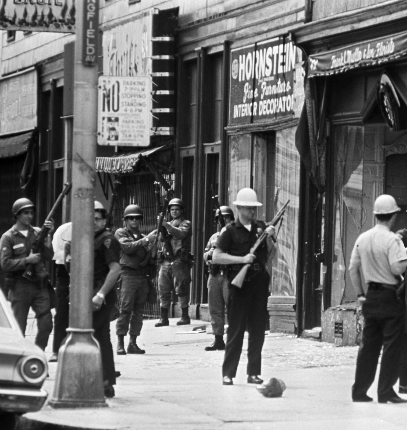 An African-American man is arrested by police officers and National Guard soldiers