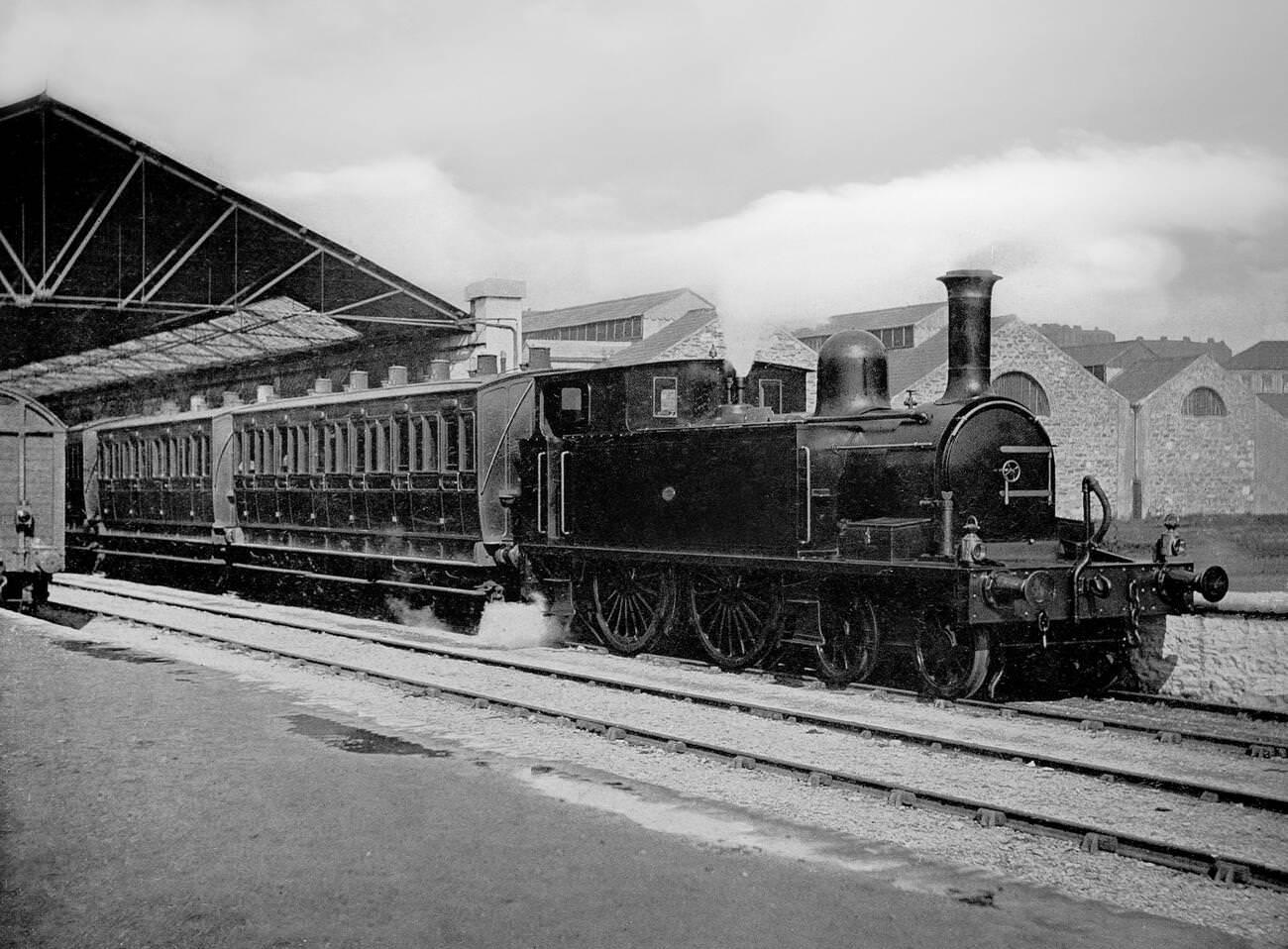 Steam locomotive pulling passenger coached out of Heuston Station.