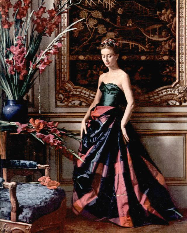 Gigi Terwalgne in an evening gown with a voluminous plaid taffeta skirt and a green taffeta bustier that laces up the back by Pierre Balmain, 1951.