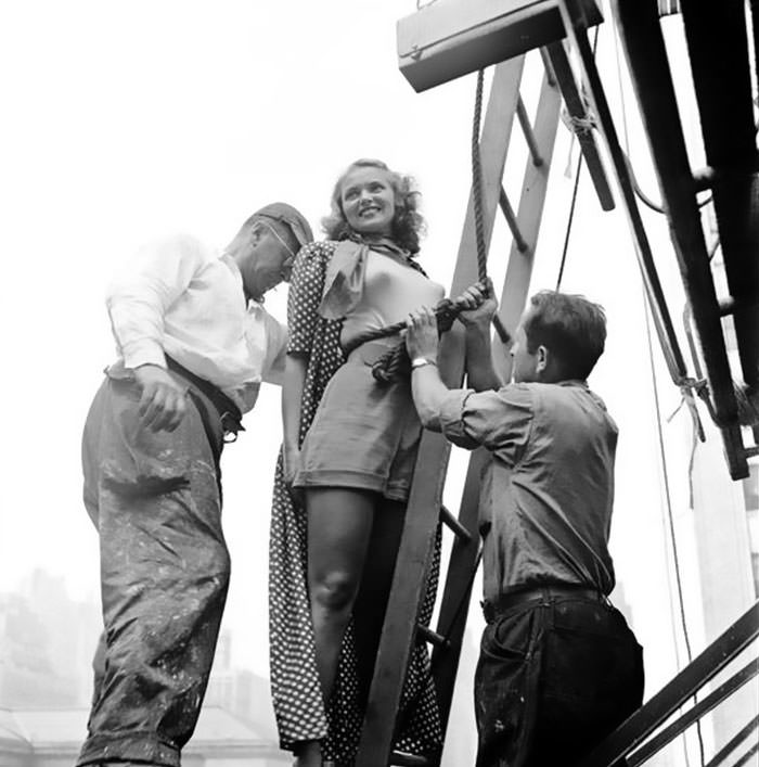 A painter tying rope around the model's waist, 1947.