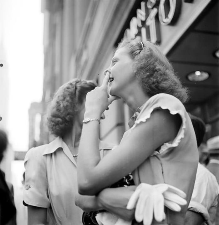 A woman watching a model being painted for a billboard, 1947.