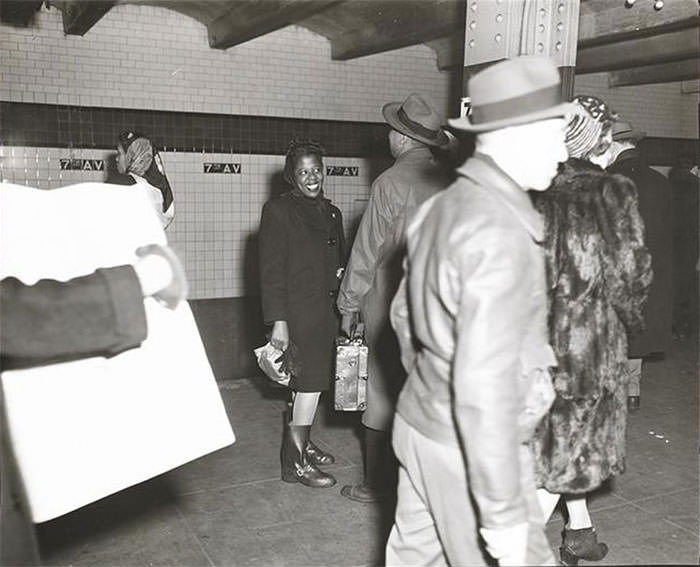 A woman waiting on a subway platform, 1940s.