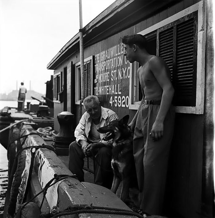 Men with a German Shepherd on a dock, 1949.