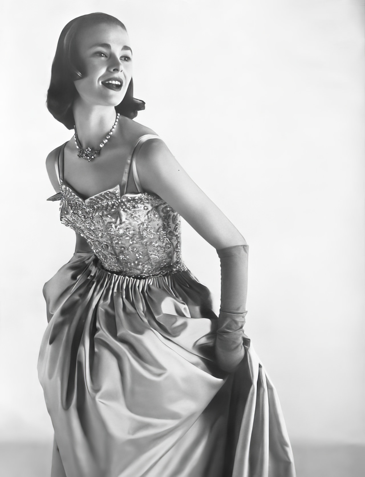 Susan Abraham in a shining ball dress of lavender satin, 1953.