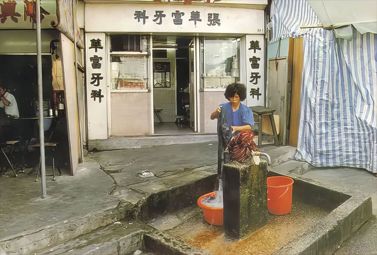 A woman fetches water in Kowloon Walled City.
