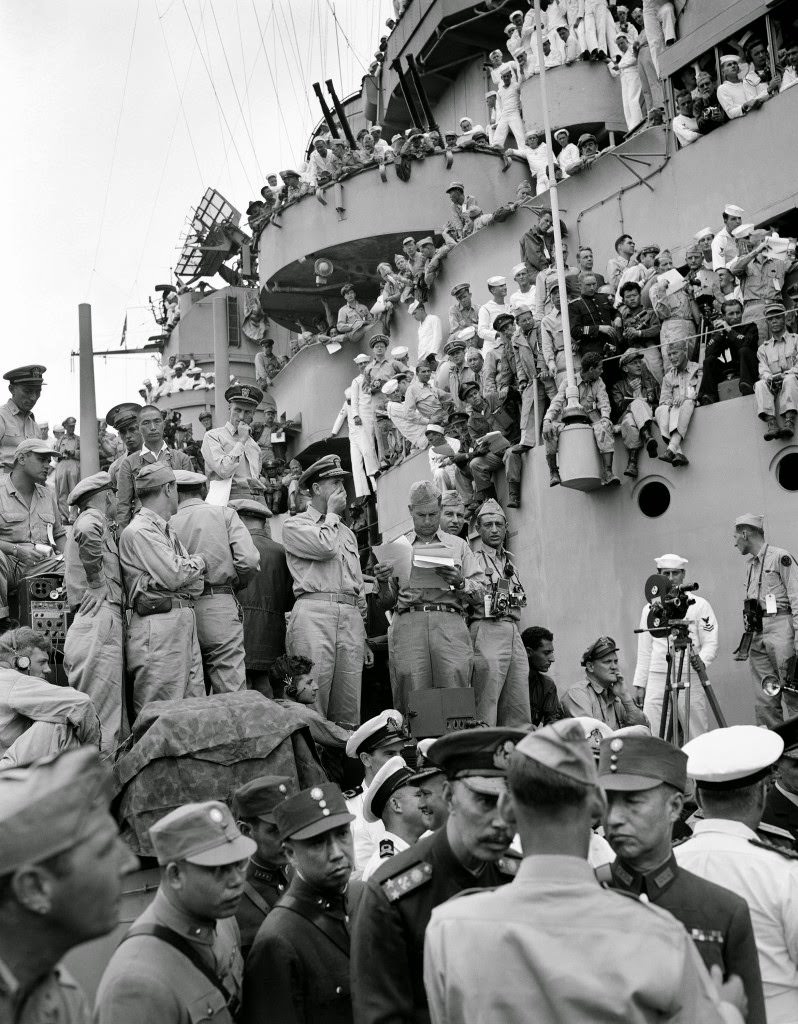Spectators and correspondents from all over the world watch the formal Japanese surrender ceremony marking the end of World War II on the deck of the USS Missouri, in Tokyo Bay, 1945.