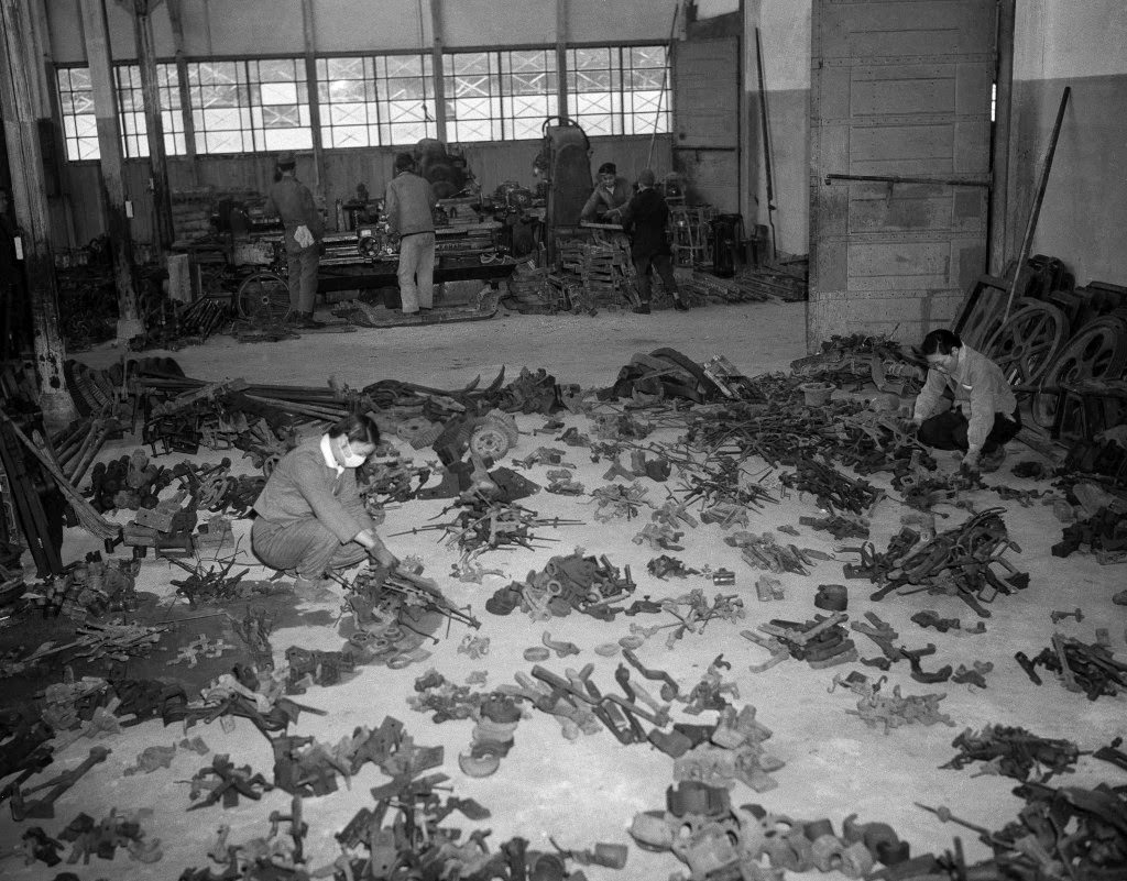 Machine tools and parts for machinery are being made with metal melted down from scrap salvaged from the wreckage of former war plants. Girl employees check salvaged material at a warehouse in Tokyo, 1946.