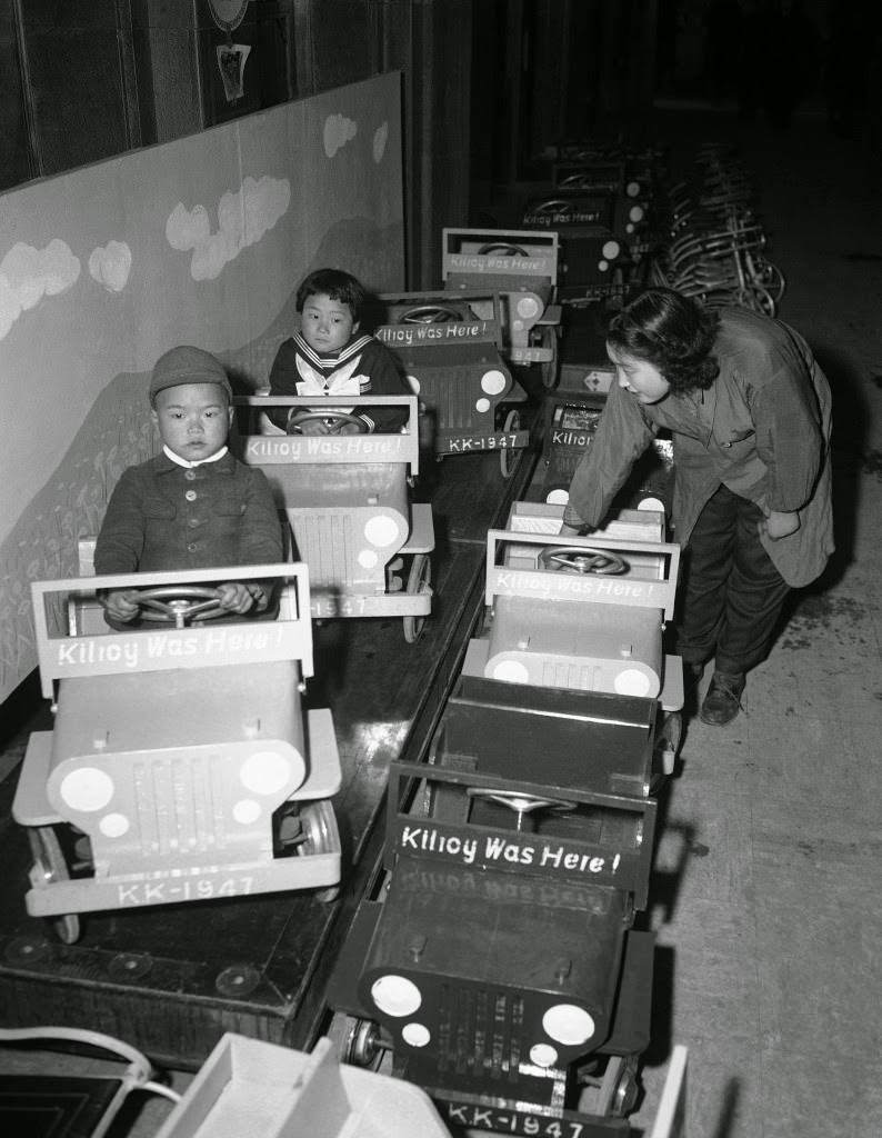 Japanese children, visiting a Tokyo department store, try out toy jeeps bearing the slogan, “Kilroy was here,” 1947.
