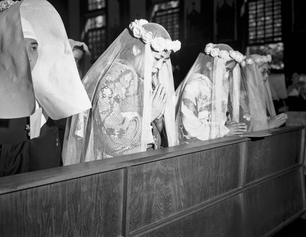 The girls offer up prayers a few minutes before they took their first vow in their first step towards sisterhood, at the altar in Tokyo, 1946.