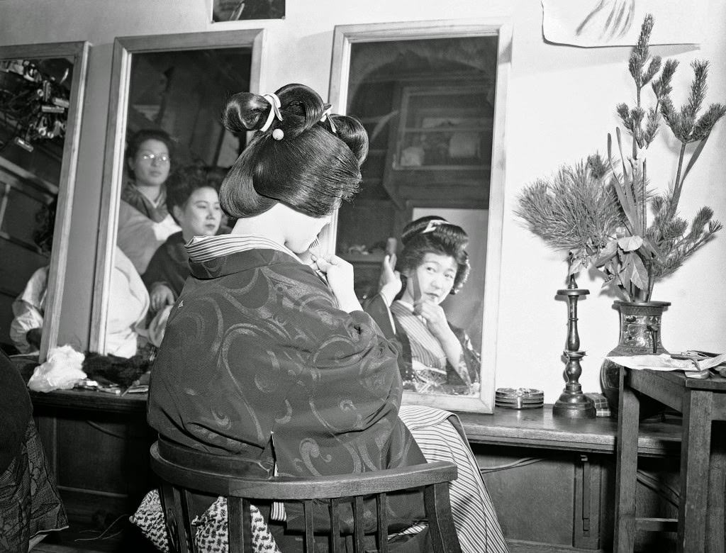 During the first weeks of the New Year, Japanese girls flock to the beauty parlors to have their hair made up in traditional Japanese style. One hopeful getting her hair done shows her coiffure almost finished at the shop on the Ginza in Tokyo, 1948.