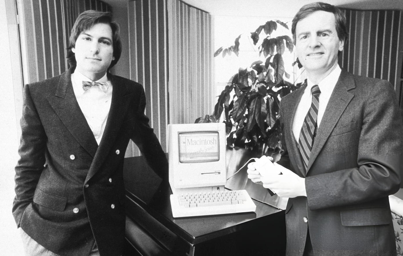 Steve Jobs and John Sculley pose with the new Macintosh personal computer, 1984