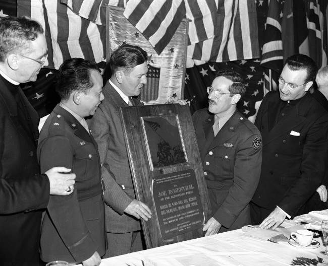 Joe Rosenthal, Associated Press photographer who took the famed Iwo Jima flag raising picture, is awarded a plaque at a Communion breakfast in New York, 1945.