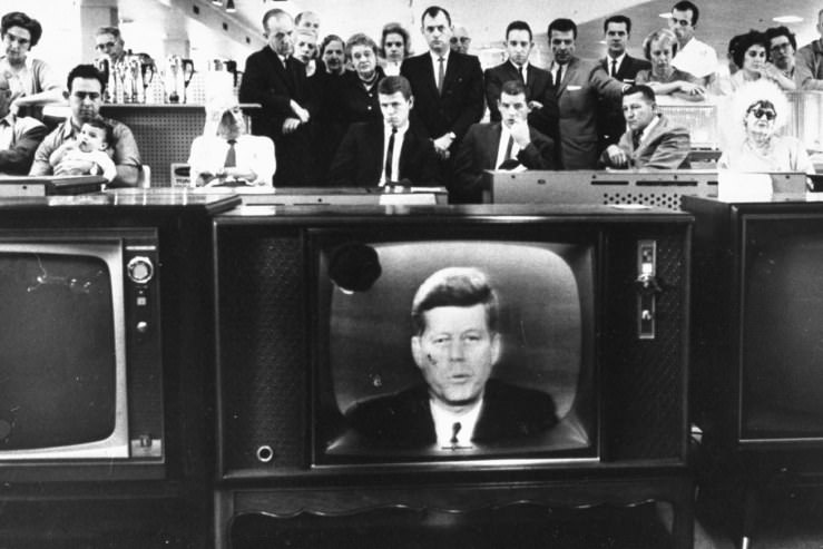 A crowd watches John F. Kennedy address the nation during the Cuban Missile Crisis, October 1962