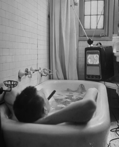 Writer Russell Finch enjoys a smoke, a bath and a TV show in 1948