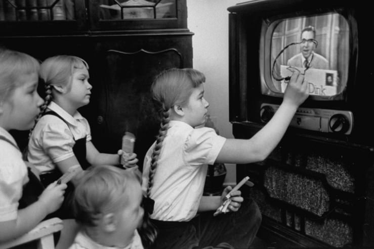 Six-year-old girls use a "Winky Dink" drawing kit on their home TV screen as they watch the kids' program.