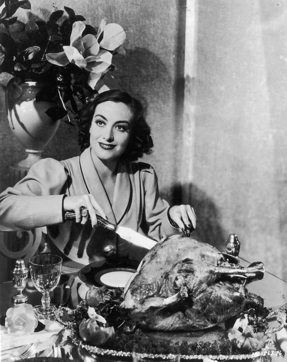 Joan Crawford carving a turkey. For a publicity shot,1930.