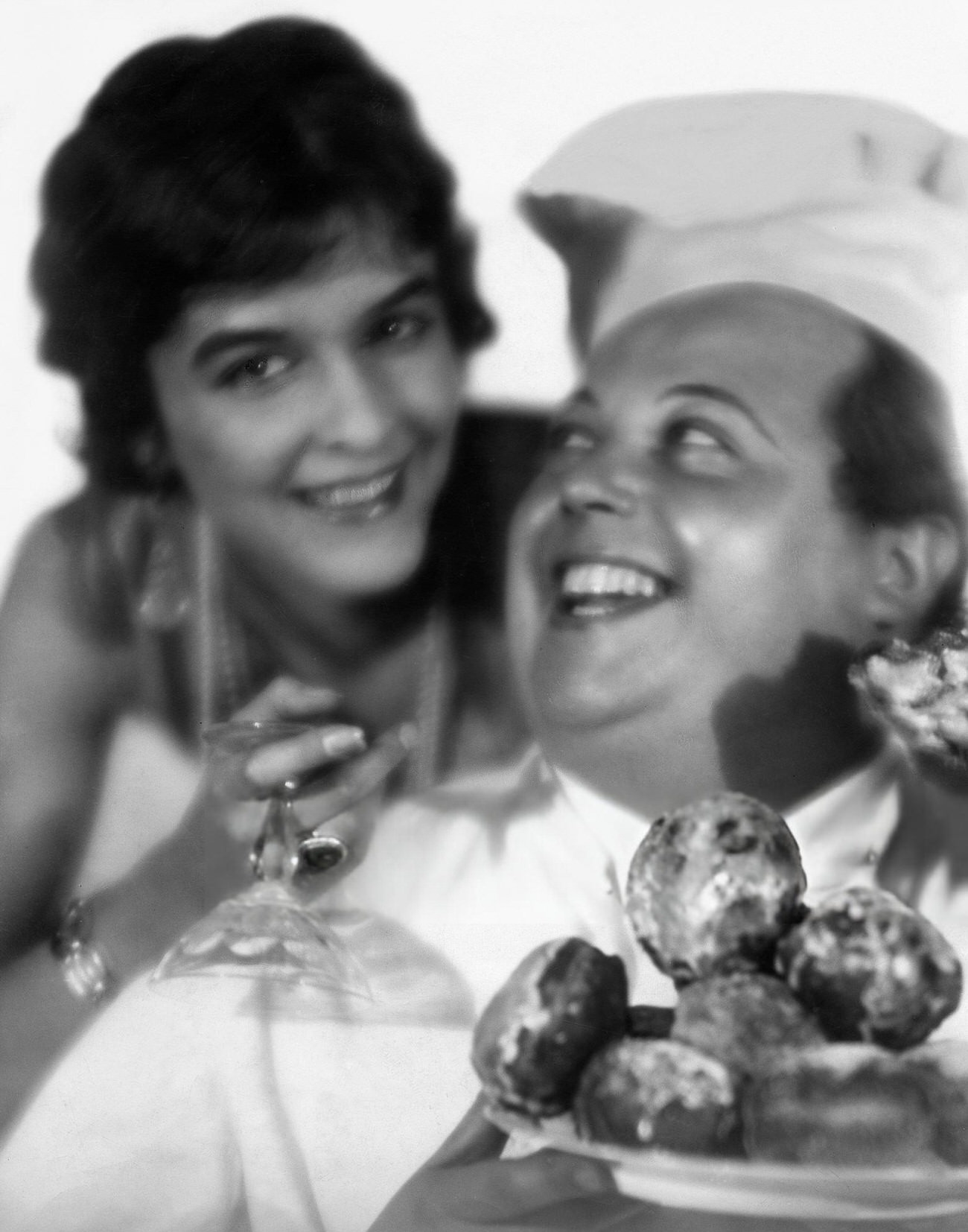 A woman and pastry cook presenting doughnuts on New Year's Eve, 1928.