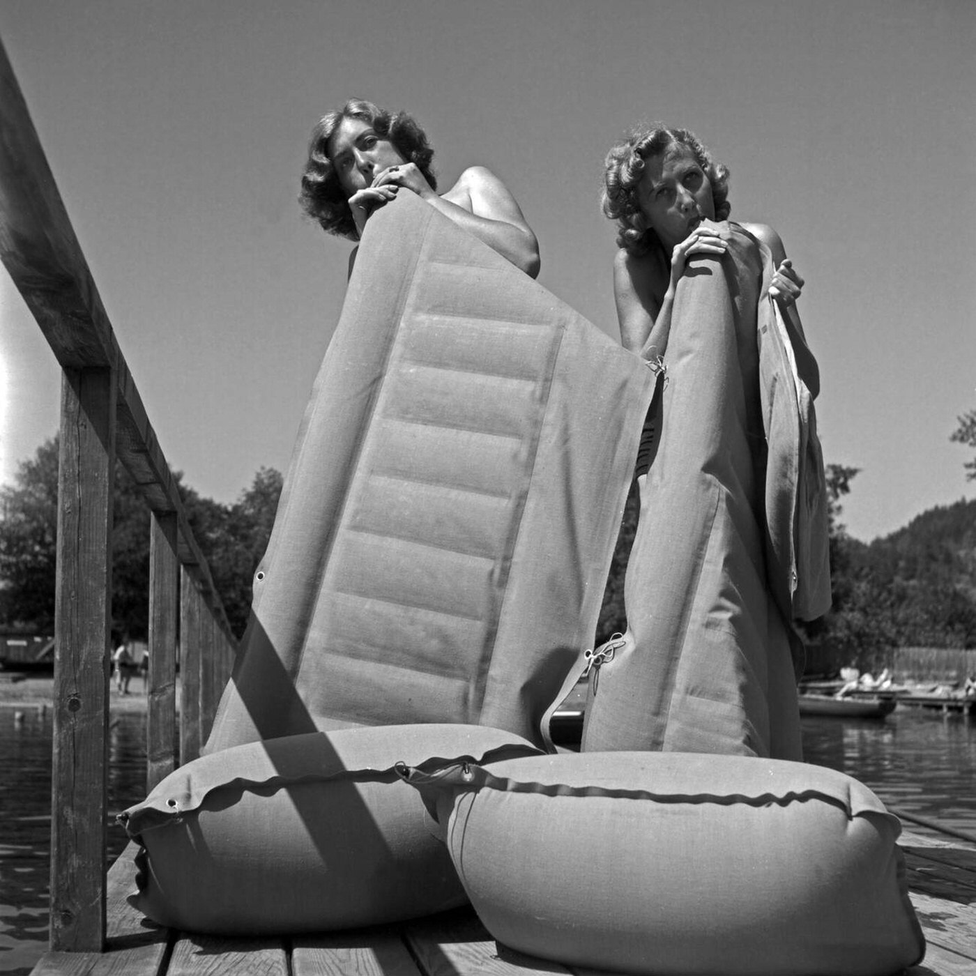 Bathgoers inflating air mattresses at an Austrian lake, 1930s.