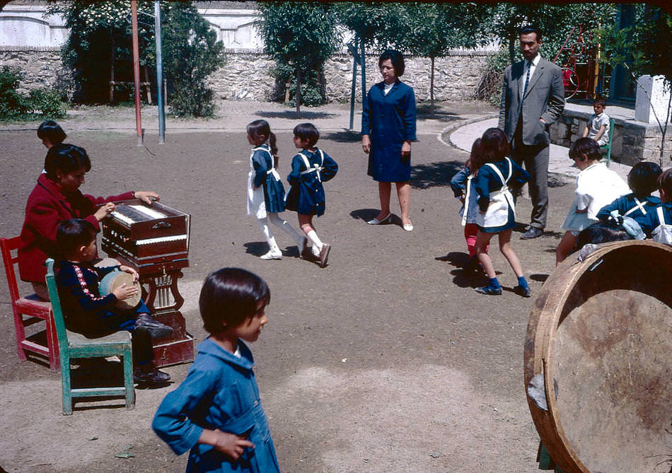 Young students dancing to music on a school playground.
