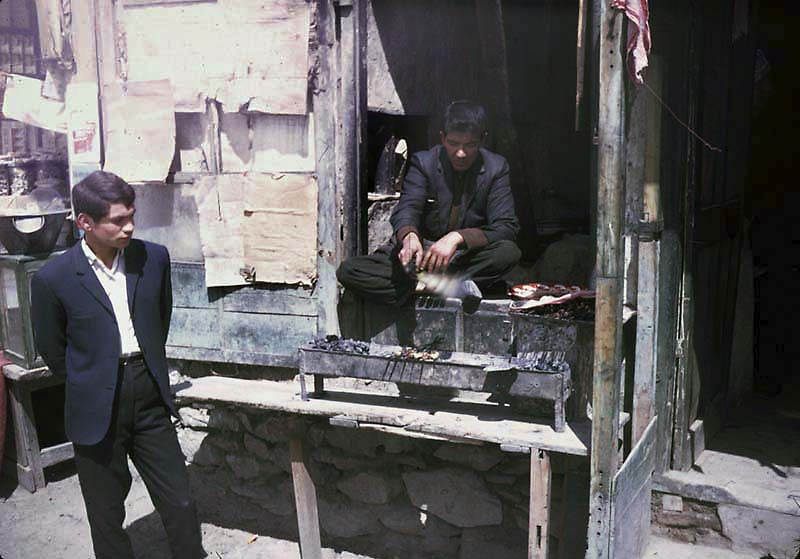 Young men cooking kebabs.