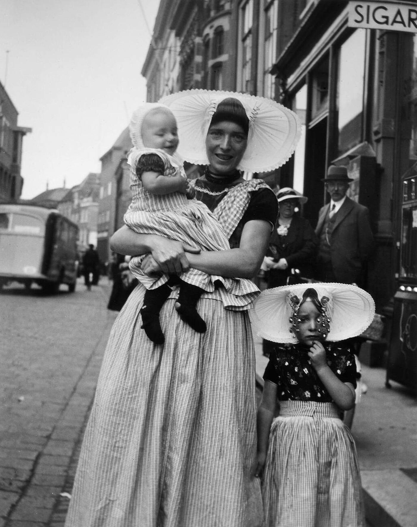 A woman and two children in traditional dress on a street in Middleburg, Holland.