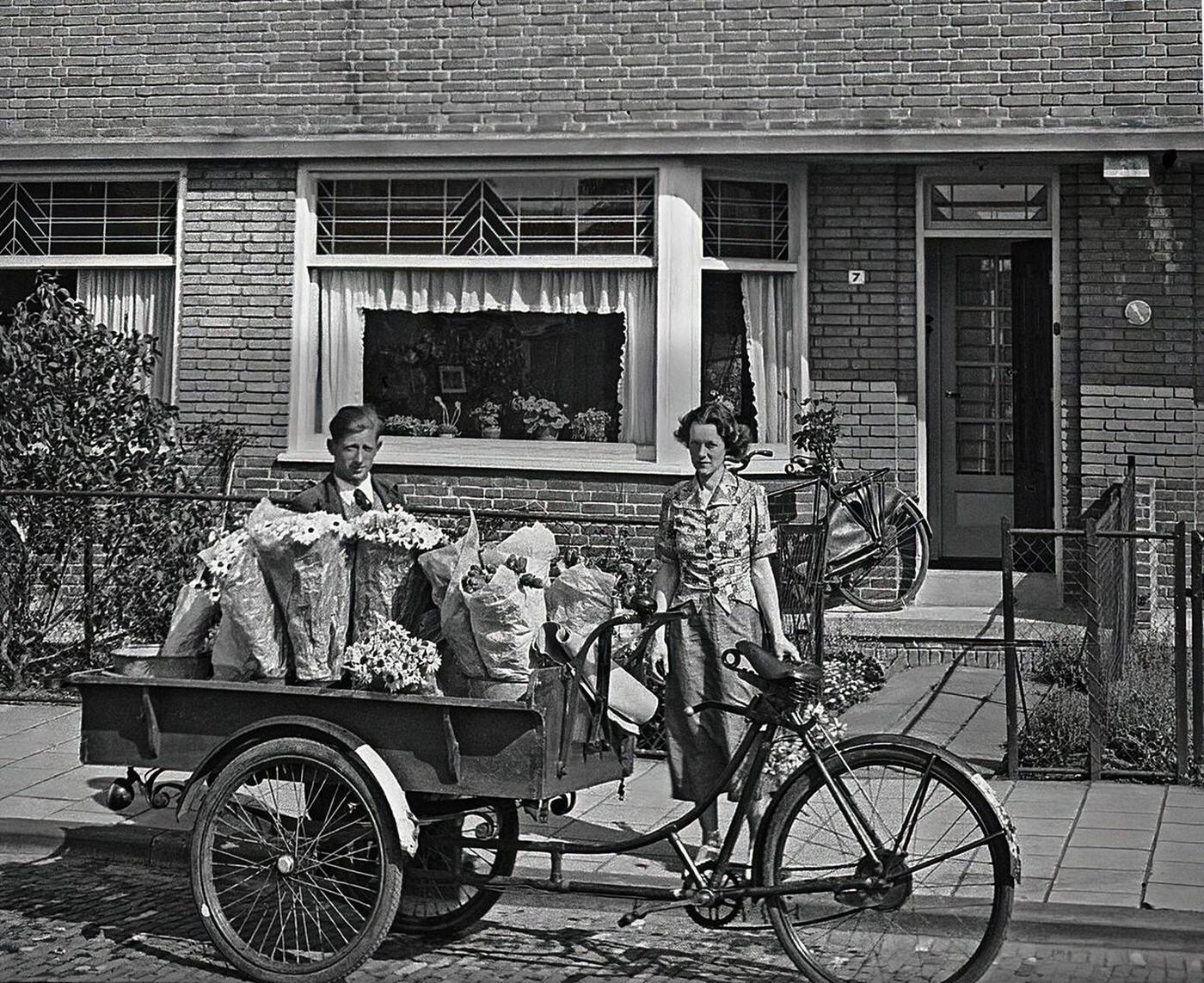 Woman purchases flowers from a door to door seller in Amsterdam, 1930s.