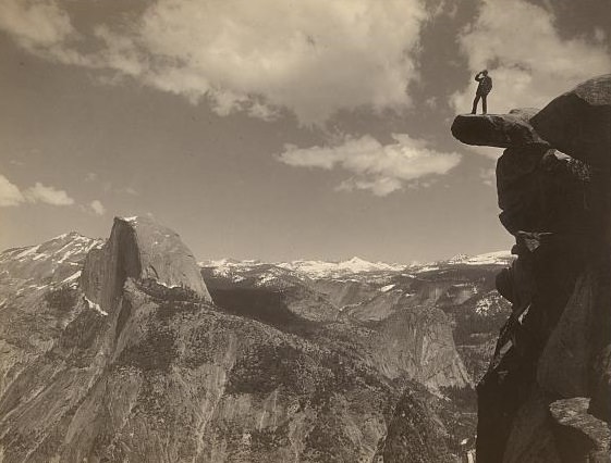 Man standing on Glacier Point, facing Half Dome in Yosemite National Park, California, ca. 1901.
