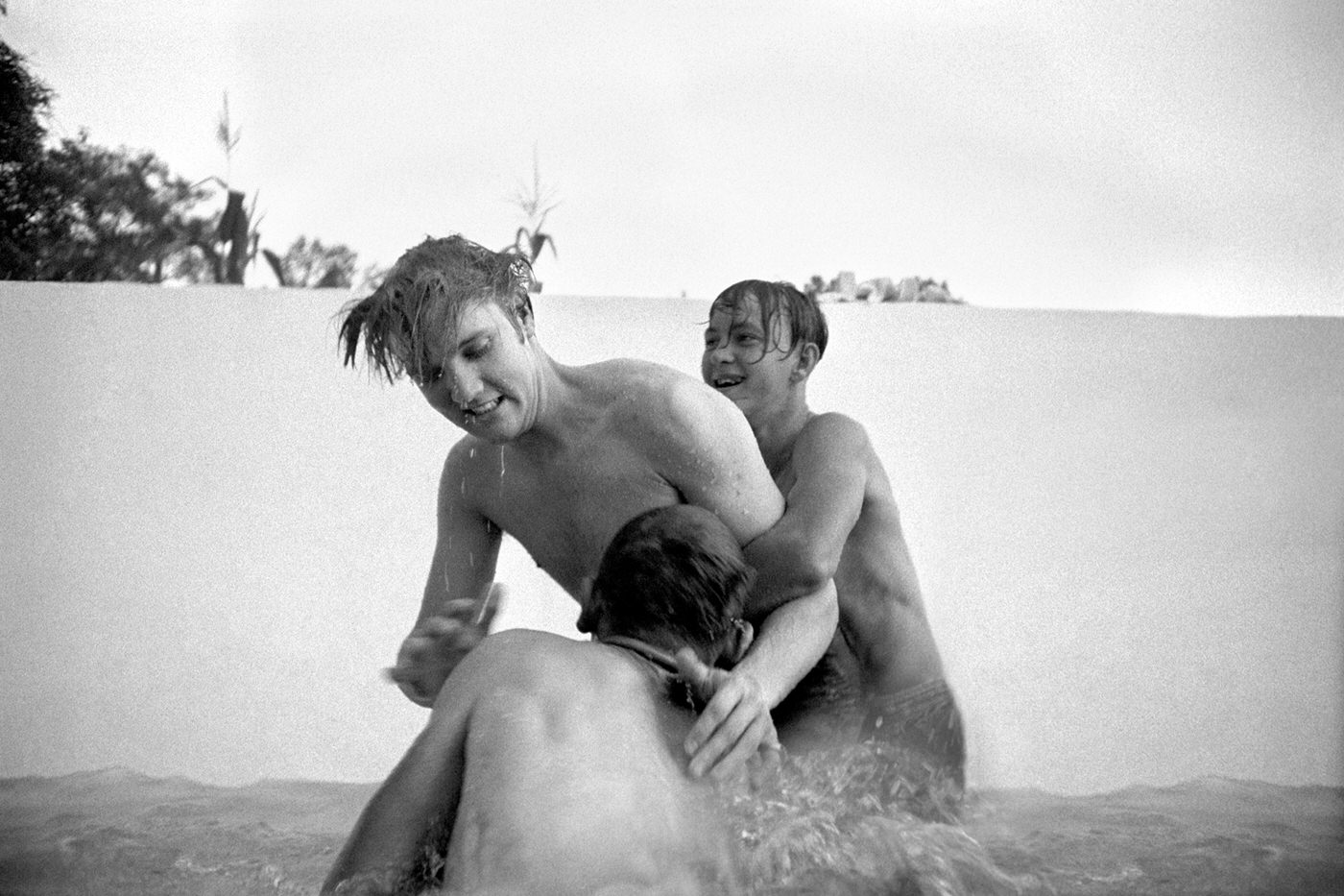 Elvis with his cousins Billy and Bobby Smith horsing around in a half-filled swimming pool at his home in Memphis, 1956.