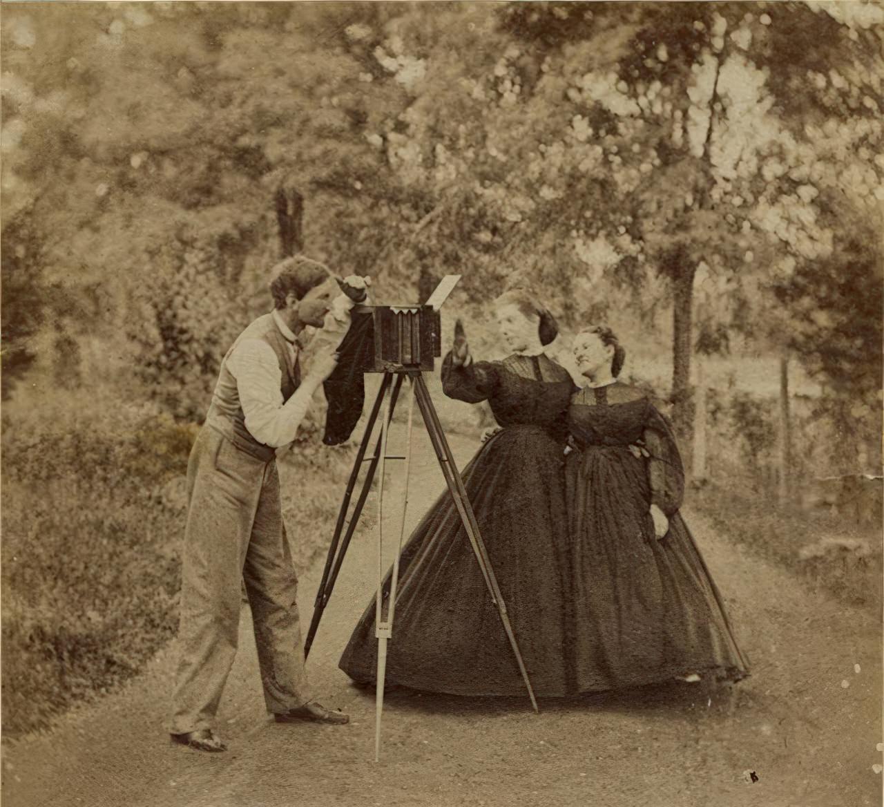 Two women in hoop skirts tease a photographer in this albumen print taken from an album of Mount Savage, Maryland photographs. The dresses suggest the 1850s/60s.