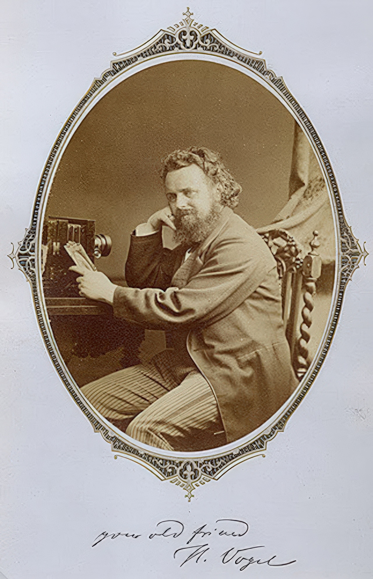 Dr. Hermann Wilhelm Vogel poses with his camera in an oval cut albumen print mounted on a gold and black decorative page. The handwritten text reads "your old friend H. Vogel" and we can not determine if it is written or printed on the mount. Vogel was a famous figure in 19th century photography and well known as the teacher of Alfred Steiglitz.