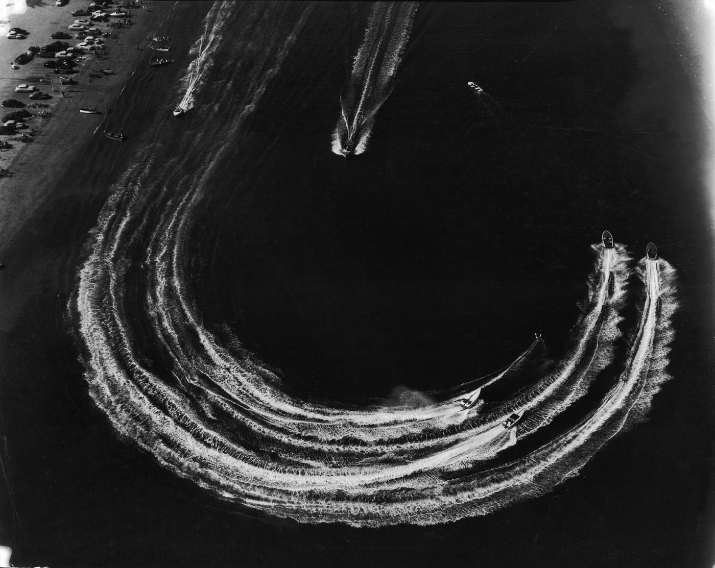 Water skiers and motorboats speed across the water, Long Beach, California