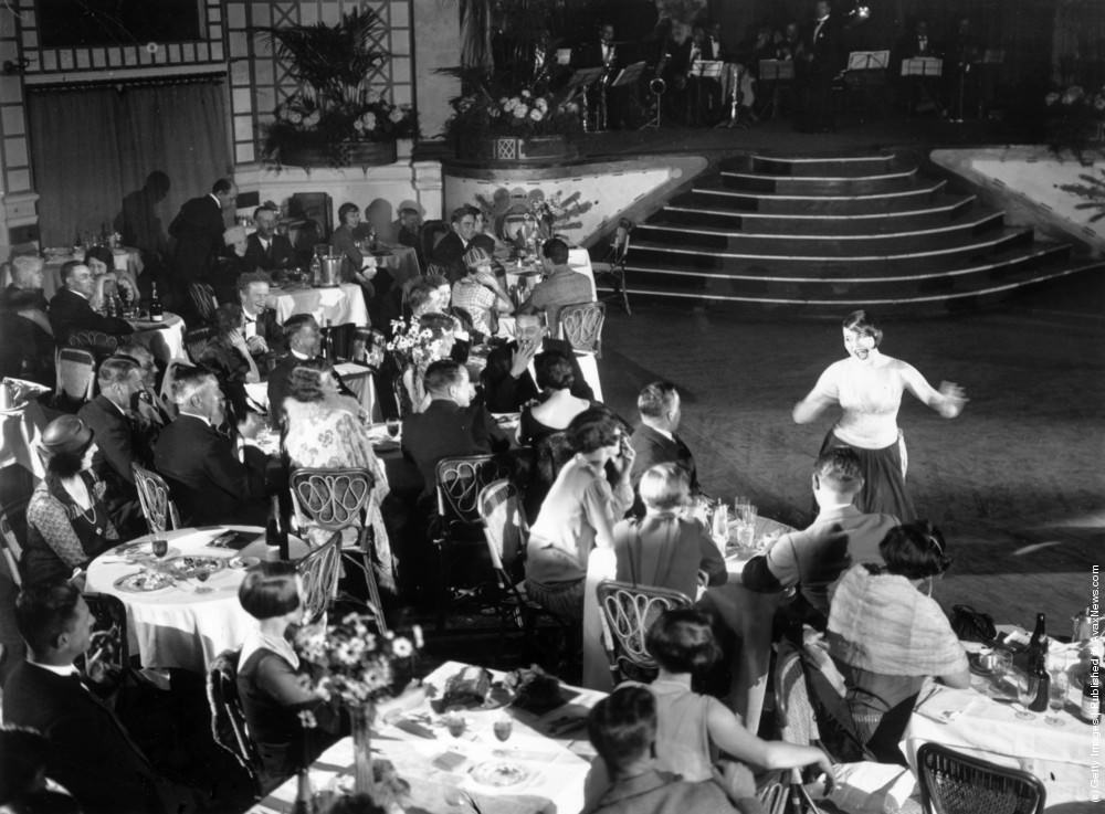 Diners and a cabaret performer at Palm Beach Cafe, London, 1926.