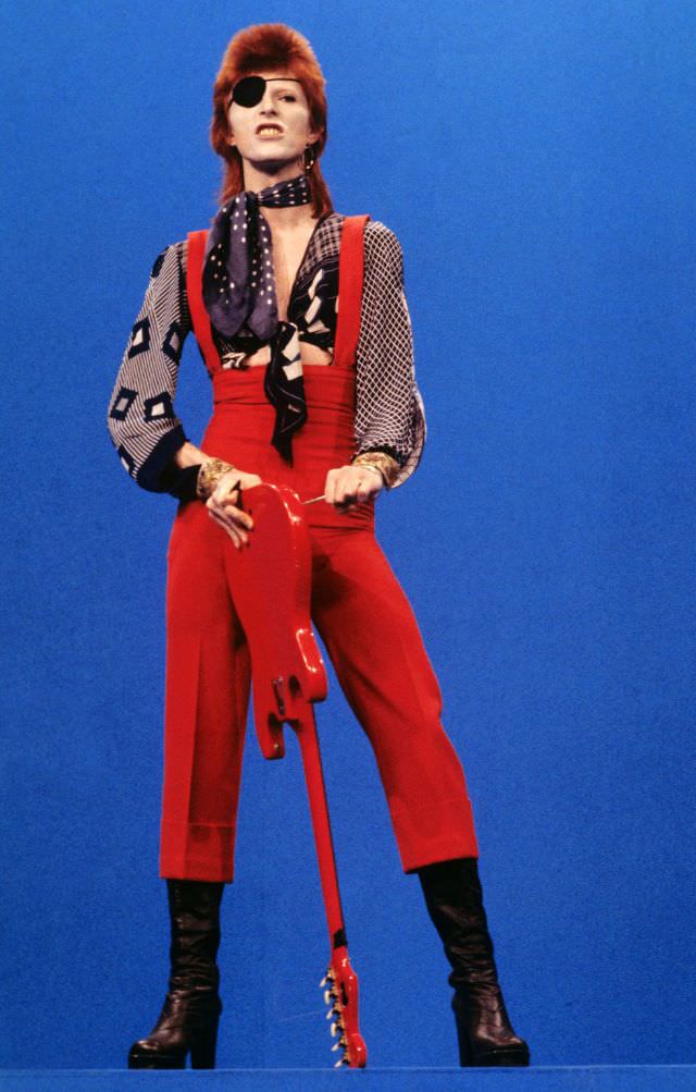 David Bowie in an eye patch and red overalls performing "Rebel Rebel" on TopPop in Hilversum, Netherlands, 1974.