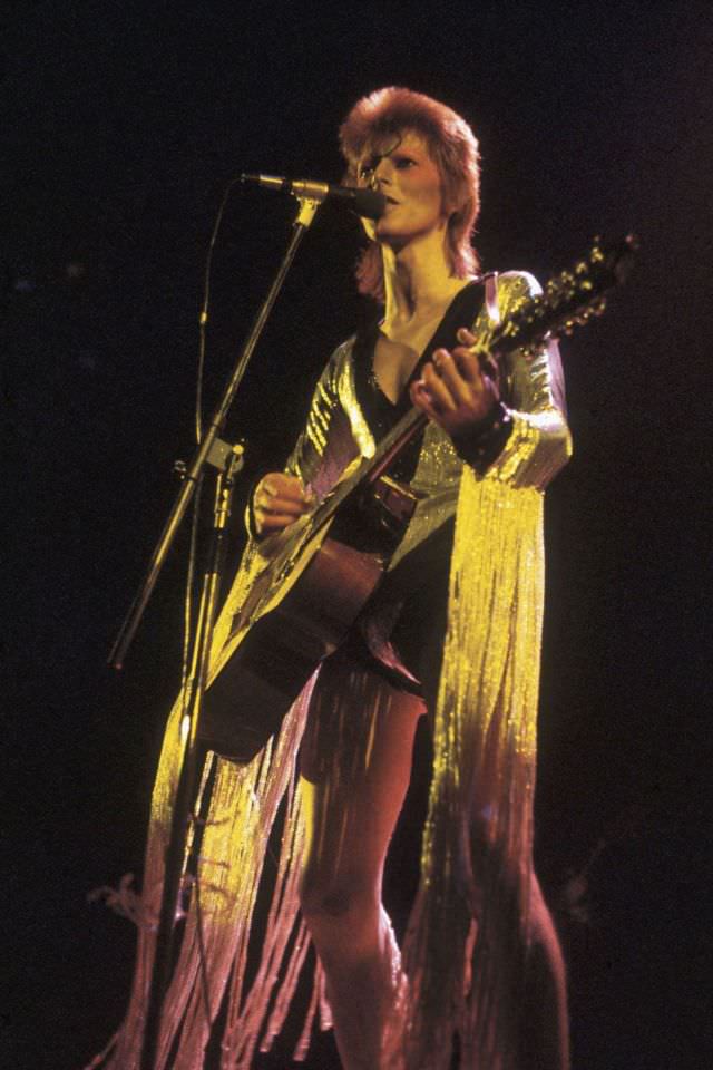 David Bowie wearing a fringed outfit by Kansai Yamamoto performing at the Hammersmith Odeon, 1973.