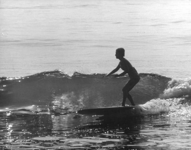 Sixteen-year-old Kathy Kohner (the real-life inspiration for the character of Gidget) rides a wave, Malibu, Calif., 1957