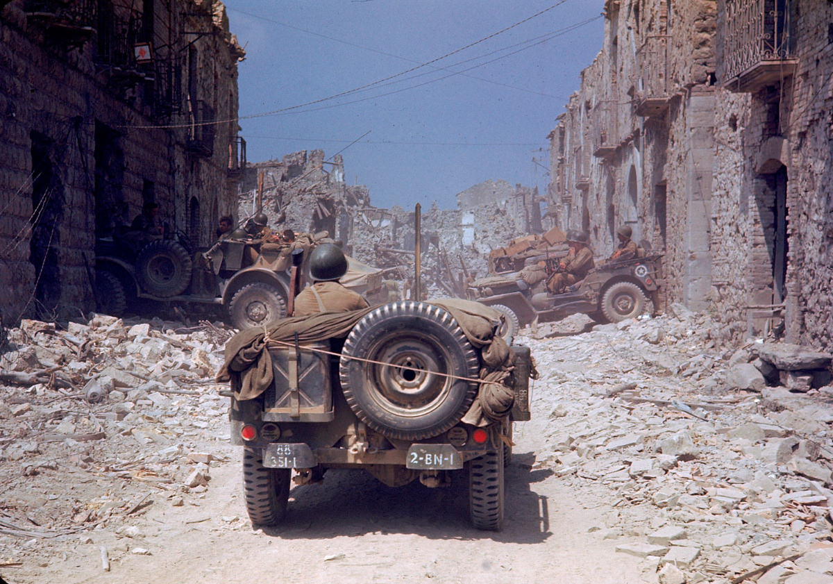 American jeeps traveled through a bombed-out town during the drive towards Rome, World War II, 1940s.