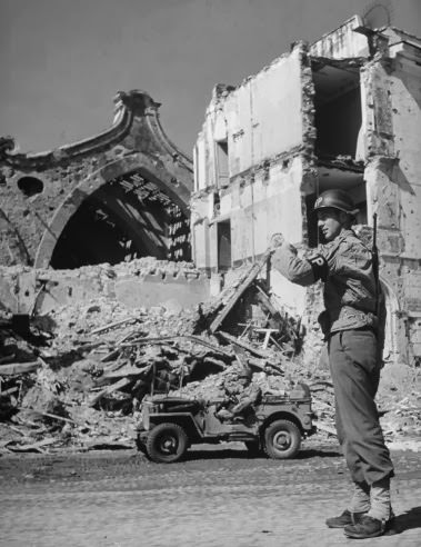 Military Policeman Ray E. Kellogg directing traffic in Anzio, 1944.