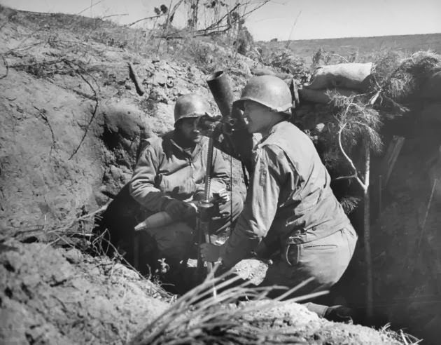 American soldiers sighting a mortar from a dugout at Anzio, 1944.