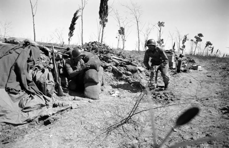 Soldiers ducking German fire at Anzio, 1944.