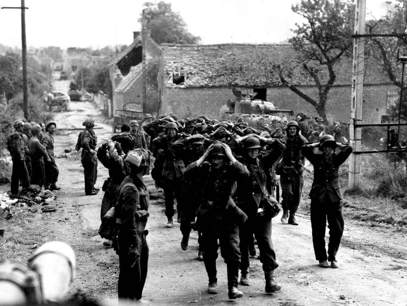 Canadian soldiers disarming German prisoners, 1944.