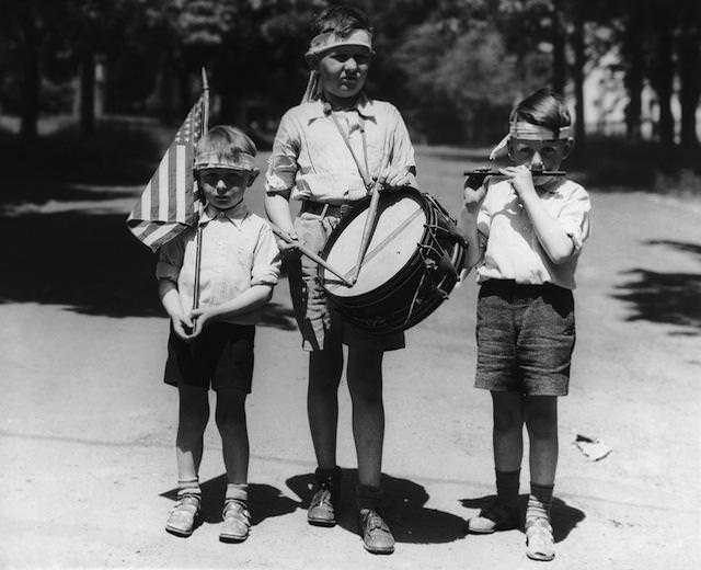 Three boys dressed as a patriotic band to celebrate Independence Day on July 4th, circa 1940.