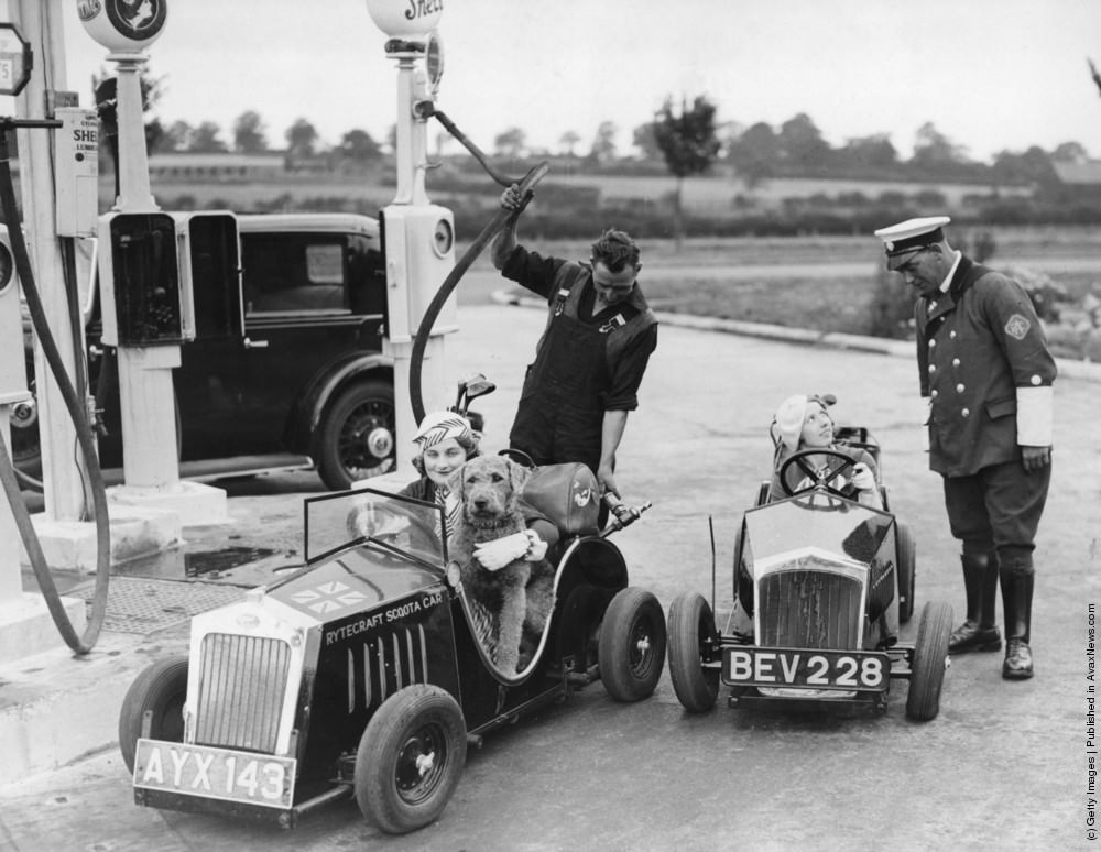 Two drivers in one horsepower cars at a filling station near Barnet, one having her tank filled and the other talking to an RAC motorcyclist. The cars, designed by J W Shillam, are fully licensed for the road and retail at £70. 4th August 1934.