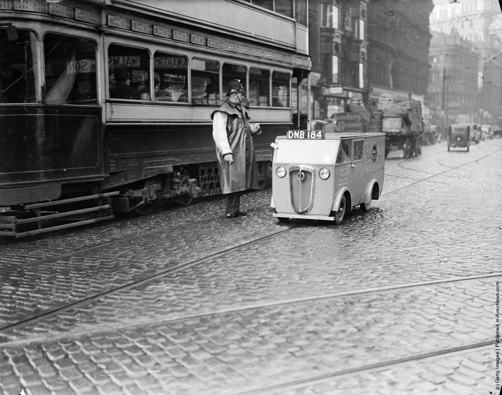 A tiny Rytecraft van, Britain's smallest, travelling along Deansgate in Manchester. The vehicle is powered by a 2 1/2 hp engine, travels 80 miles on a gallon of petrol, carries nearly 600 pounds and has a top speed of 50 mph. 17th February 1937.