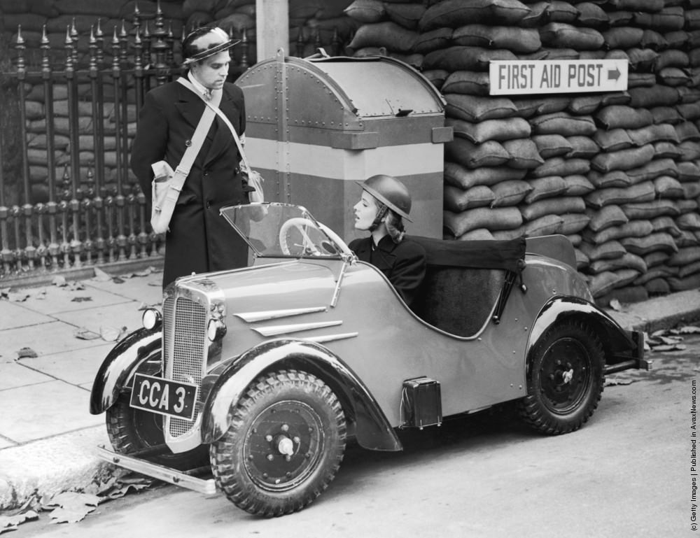 An air raid warden arrives at a shelter in a Rytecraft midget car. 1939.