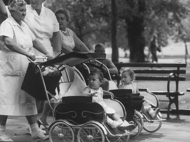 The park's carriage trade, out for a morning ride, moves in conversational formation along a broad pavement