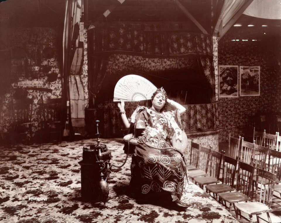 Woman gypsy/dancer seated in her side-show theatre at Coney Island, ca 1896.