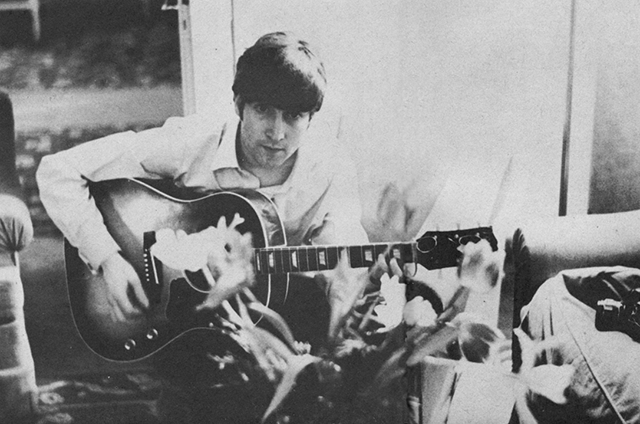 John Lennon and Paul McCartney composing songs on guitar.